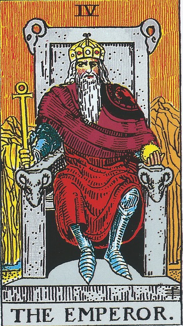 Tarot Card - The Emperor
A crowned man with a long white beard sits on a throne.  He is wearing mail, over which are red robes of state.  In his left hand is a scepter with an Egyptian ankh, and his right holds a golden globe.  His stone throne is adorned with rams heads.  The background is orange and there are rocky crags with a small river at the base of them.   